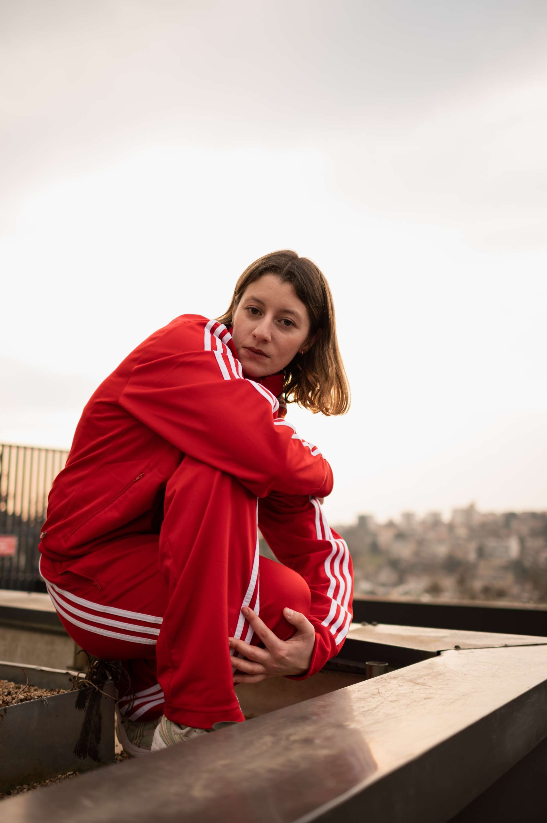Fiona Le Goff assise en ville en jogging rouge